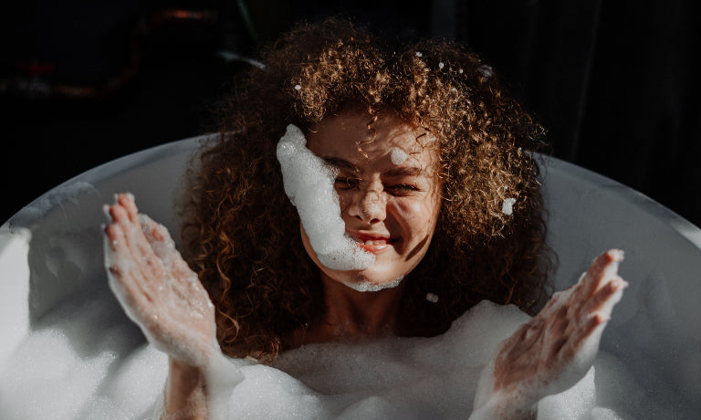 Woman with curly hair having bath
